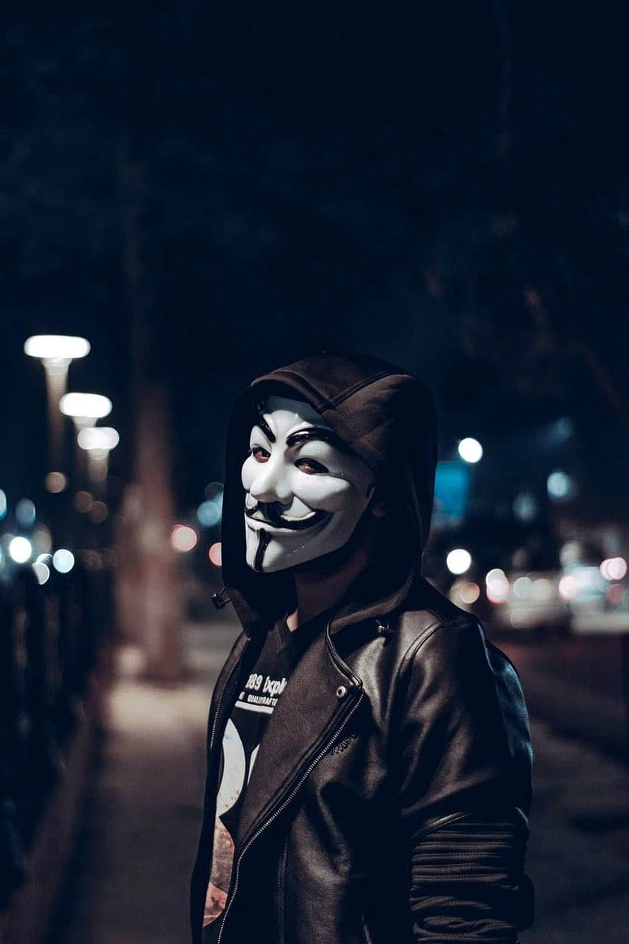 Person in Guy Fawkes Mask and Leather Jacket on a Dark City Street at Night HD phone wallpaper